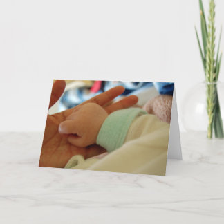 Erstmaliger Vater mit der Hand-Grußkarte des Babys Karte