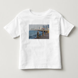 Fahrrad am Wasser mit der Skyline der Stadt Yantai Kleinkind T-shirt