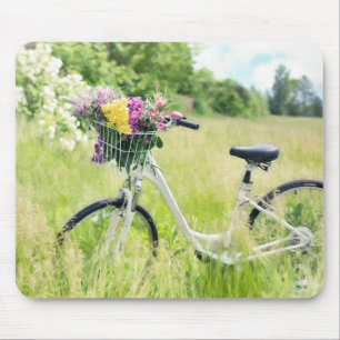 Fahrrad mit Korb der Blume auf der Wiese Mousepad
