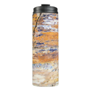 Farbenfrohe Natursteinmauer in einem Steinbruch Thermosbecher