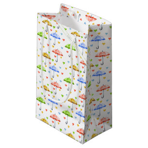 Farbenfrohe Wasserfarbenschirme und herabfallende  Kleine Geschenktüte