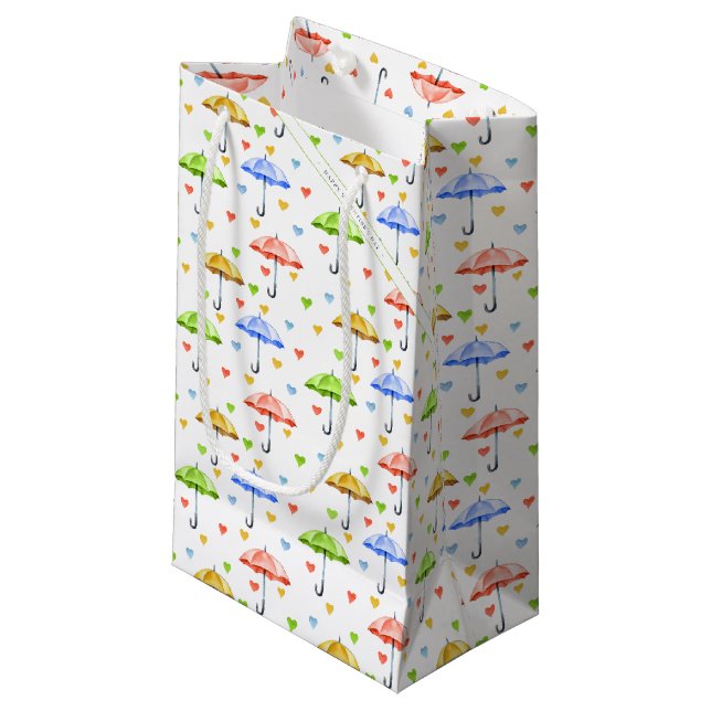 Farbenfrohe Wasserfarbenschirme und herabfallende  Kleine Geschenktüte (Vorderseite Schrägansicht)
