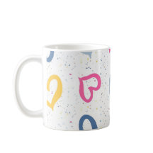 Farbige Herzchen und gesprenkelter Kaffeebecher mi