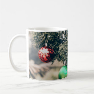 Farbige Weihnachtskugel-Dekoration auf einem Baum. Kaffeetasse