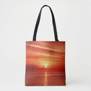 Farbiger Sonnenaufgang auf See, dramatische Wolken Tasche