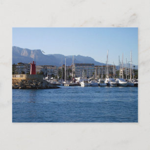 Faro rojo y veleros en el puerto postkarte