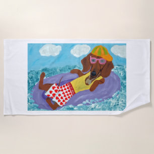 Fauler Dachshund auf einem Floß Strandtuch