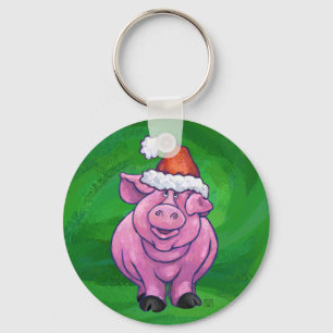 Feierliches Schwein in Weihnachtsmannmütze auf Grü Schlüsselanhänger