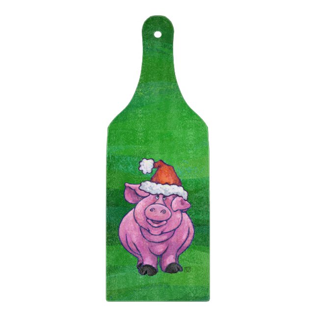 Feierliches Schwein in Weihnachtsmannmütze auf Grü Schneidebrett (Vorderseite)