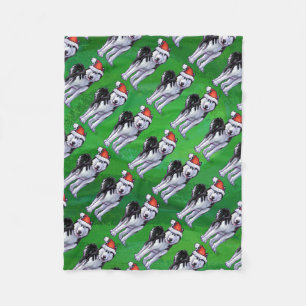 Feiernder Husky in Weihnachtsmannmütze auf Green Fleecedecke