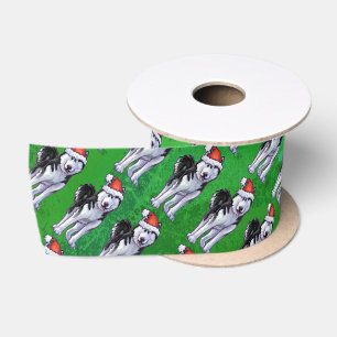 Feiernder Husky in Weihnachtsmannmütze auf Green Satinband