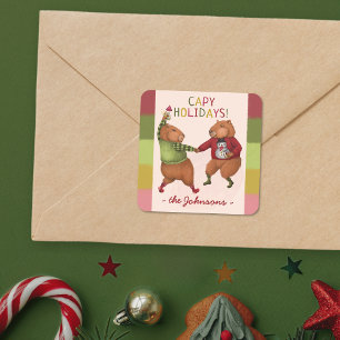 Festliche Capybara Weihnachtspuppe mit Familiennam Quadratischer Aufkleber