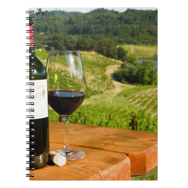 Flasche Rotwein und Glas auf dem Tisch Notizblock (Vorderseite)