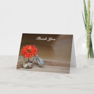 Fleur orange dans un pot Mason Merci