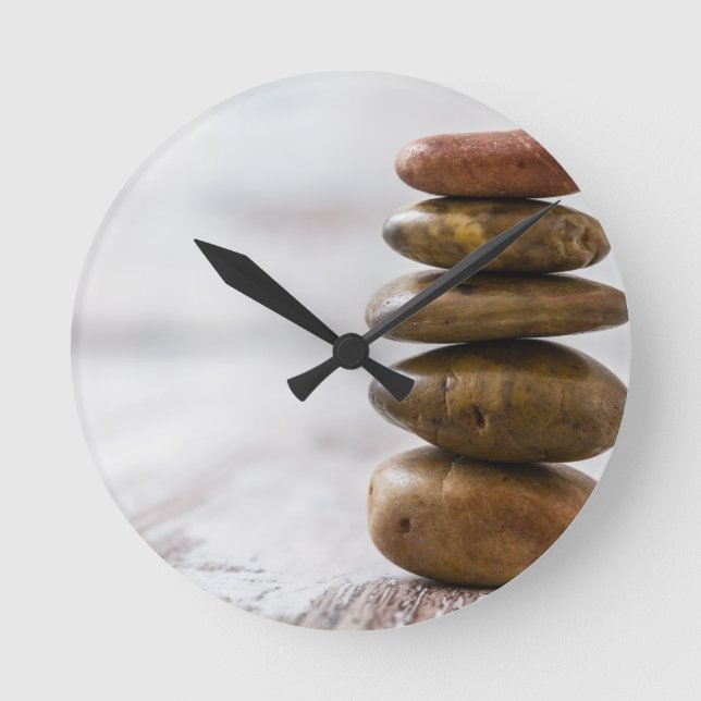 Fliesen aus dunkelfarbenen Steinen auf weißem Hint Runde Wanduhr (Vorderseite)