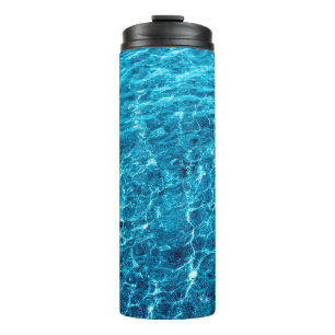 Foto eines makro sprudelnden blauen klaren Wassers Thermosbecher