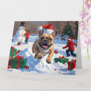 Französische Bulldogge läuft im Schnee mit Weihnac Karte