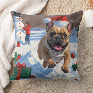 Französische Bulldogge läuft im Schnee mit Weihnac Kissen