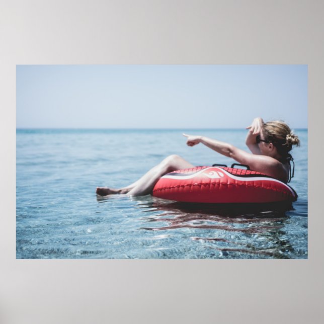 Frau auf einem aufblasbaren Schwimmer im Ozean, de Poster (Vorne)