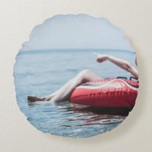 Frau auf einem aufblasbaren Schwimmer im Ozean, de Rundes Kissen