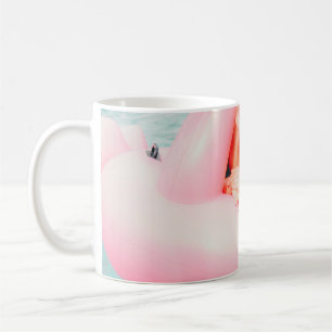 Frau auf rosa aufblasbarem Flamingo im Außenpool Kaffeetasse