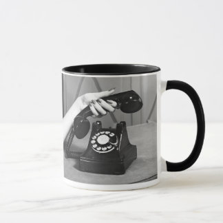 Frau, die oben das Telefon nah von der Hand Tasse