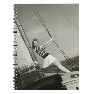 Frau, die Takelung auf Yacht hält Notizblock