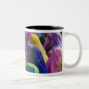 Frauen in farbenfrohen Saris versammeln sich Zweifarbige Tasse
