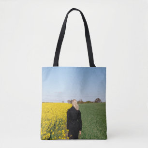 Frauen in schwarzem Mantel stehend auf grünem Gras Tasche