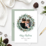 Frohe Weihnachten Rustikale Grünanlage Kraut Foto<br><div class="desc">Elegantes "Frohe Weihnachten" Fotokartendesign mit einem rustikalen, schicken runden Kranz aus Winterwasserfarbe, der das Familienbild umrahmt und die moderne grüne und kohlegraue Formulierung betont. Personalisieren Sie mit Ihrem Nachnamen und dem Jahr. Enthält eine zusätzliche Meldung mit Familiennamen und Bonuslandschafts-Foto auf der Kartenrückseite. Weiße und weiche grüne Hintergrundfarben können modifiziert werden....</div>