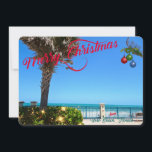 Frohe Weihnachten von Vero Beach Florida Ozean<br><div class="desc">Frohe Weihnachten von Vero Beach, Florida! Diese farbenfrohe, tropisch gestaltete, flache Grußkarte zeigt ein Foto eines wunderschönen Strandviertels von Vero Beach, das alle für die Ferien verziert ist. Das festliche Design umfasst Weihnachtsbeleuchtung im Grünen, Weihnachtsbälle, die an einer Palmenfront hängen, und den Text "Frohe Weihnachten" in roter Schrift, der sich...</div>