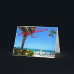 Frohe Weihnachten von Vero Beach Florida Ozean<br><div class="desc">Frohe Weihnachten von Vero Beach, Florida! Diese farbenfrohe, tropisch gestaltete Grußkarte zeigt ein Foto eines wunderschönen Strandviertels von Vero Beach, das für die Ferien voll ausgestattet ist. Das festliche Design umfasst Weihnachtsbeleuchtung im Grünen, Weihnachtsbälle, die an einer Palmenfront hängen, und den Text "Frohe Weihnachten" in roter Schrift, der sich perfekt...</div>