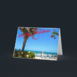 Frohe Weihnachten von Vero Beach Florida Ozean<br><div class="desc">Frohe Weihnachten von Vero Beach, Florida! Diese farbenfrohe, tropisch gestaltete Grußkarte zeigt ein Foto eines wunderschönen Strandviertels von Vero Beach, das für die Ferien voll ausgestattet ist. Das festliche Design umfasst Weihnachtsbeleuchtung im Grünen, Weihnachtsbälle, die an einer Palmenfront hängen, und den Text "Frohe Weihnachten" in roter Schrift, der sich perfekt...</div>