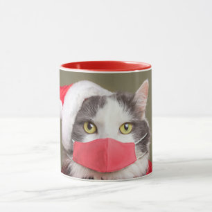 Frohe Weihnachtskatze in Weihnachtsmannmütze und G Tasse