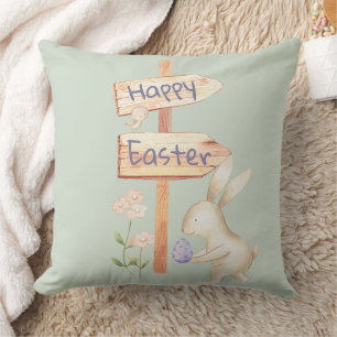 Fröhlicher Osterhase und Ei auf Grün Kissen