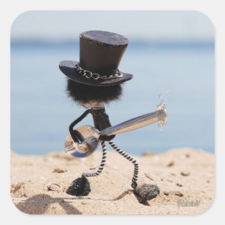 Fubby rock gitarist met hoed op het strand. quadratischer aufkleber