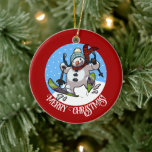 Funny Snowman Frohe Weihnachten! Skifahren Cartoon Keramik Ornament<br><div class="desc">Ein fröhlicher Schneemann auf einer Keramik für deinen Weihnachtsbaum. Verwenden Sie "Personalisieren Sie diese Vorlage", um den Text "Frohe Weihnachten!" zu optimieren und ein einzigartiges, individuelles Geschenk zu erstellen. Mit einem niedlichen Schneemann mit Karottennase und Kohleaugen, Schneeschlitten durch den Schnee, in Wollhut und Tartan Schal, auf rotem Hintergrund. Ein optimistisches...</div>
