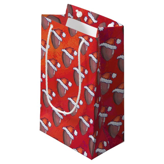 Fußball in Weihnachtsmannmütze über Rot Kleine Geschenktüte (Vorderseite Schrägansicht)