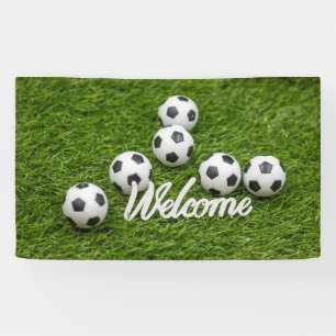 Fußball mit Begrüßungszeichen auf grünem Gras Banner