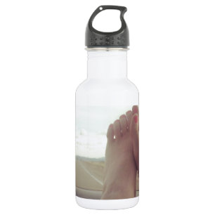 Füße auf dem Armaturenbrett Trinkflasche