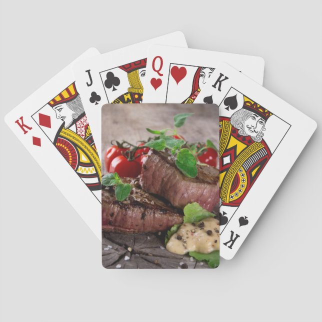Gegrillte Grillensteaks mit frischen Kräutern und Spielkarten (Rückseite)