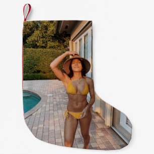 Gelbbikini-Frau stehend auf Braunziegelflur Kleiner Weihnachtsstrumpf