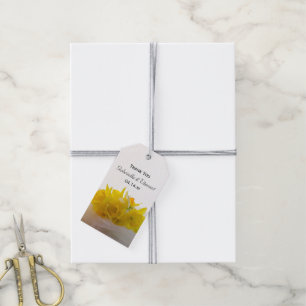 Gelbe Daffodien auf der Hochzeitstagung des weißen Geschenkanhänger