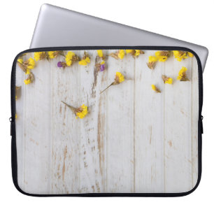Gelbe Frühlingsblumen, weiße Putz. Laptopschutzhülle