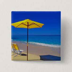 Gelbe Sonnenschirme und Strandstühle auf makellose Button
