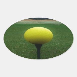 Gelber Golfball auf dem Golfplatz Ovaler Aufkleber
