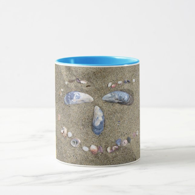 Gelbes Gesicht der Tasse gemacht im Sand mit (Zentrum)