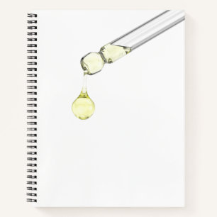 Gelbes Serum aus einer Pipette tropfen lassen Notizbuch