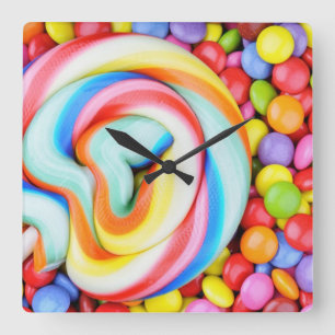 Gestreifter Lutscher und mehrfarbige Smarties Quadratische Wanduhr