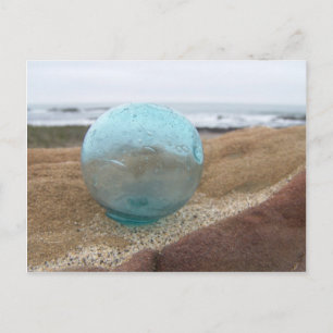 Glas schwimmt am Strand auf Sand Postkarte